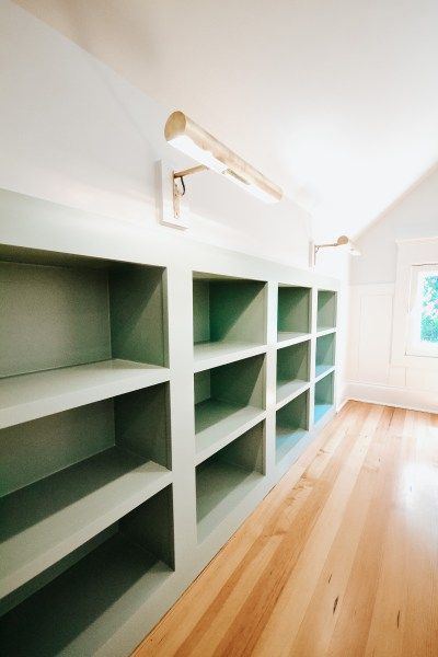 custom built-in bookshelves, bookshelf lights, attic bedroom nook, reading nook, window seat, custom built-ins Attic Renovation Playroom, Built In Shelves Knee Wall, Playroom Sloped Ceiling, Modernize Victorian Home, Attic Library Sloped Ceiling, Attic Room Storage Ideas, Office Attic Ideas, Attic Cabinets, Attic Shelving