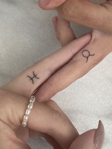 Pisces Taurus astrology star sign tattoo fine line finger tat jewellery matching aesthetic 2022 Finger Tattoos Pisces, Tattoo Ideas Zodiac Signs Taurus, Star Sign Finger Tattoo, Water Tribe Symbol Tattoo, Small Pisces Sign Tattoo, Taurus Tattoo Finger, Taurus Tattoo On Finger, Pisces Taurus Tattoo, Tiny Matching Finger Tattoos