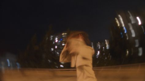 Still frame from music video for “Junk Mail” by Vancouver indie-rock band, Slightest Clue. Image captured using slow shutter speed for a dreamy aesthetic look. Hannah stands in a fluorescent lit parking lot at night, with glowing apartment buildings behind her. She is screaming and running her hands through her hair, which looks blurred by the slow shutter speed. The result is a dreamy, edgy, and alternative looking style of photography. Indie Music Video, Motion Blur Film Photography, Indie Short Film Aesthetic, Slow Shutter Speed Photography Lights, Slow Shutter Street Photography, Orange Night, Night Exterior Cinematography, Aesthetics Tumblr, Alt Indie