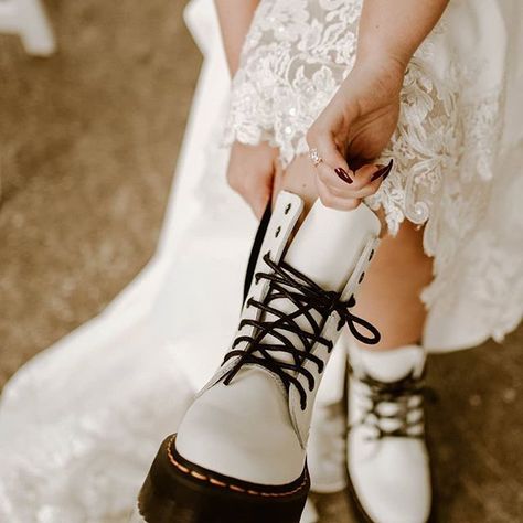 A pair of white Doc Martens boots paired with a gorgeous white, lace wedding dress. Who says you have to follow the norm for your wedding day. #weddingdress #weddinginspiration #weddingdressinspo #dressideas #engaged #bridetobe #whiteweddingdress #docmartensoutfit #weddingoutfit Bride Boots, Cinematic Documentary, Wedding Dress Cheap, Wedding Dress Details, White Doc Martens, Biker Wedding, Edgy Wedding, Rock N Roll Wedding, Wedding Dr