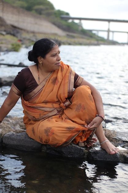 Indian women sitting near river, indian ... | Premium Photo #Freepik #photo #riverside #villager #indian-women #women-from-village-saree Indian Sitting, Tamil Village, Indian Character, Women In Saree, Watching Sunset, Memory Drawing, Figure Sketches, Village Women, Face Structure