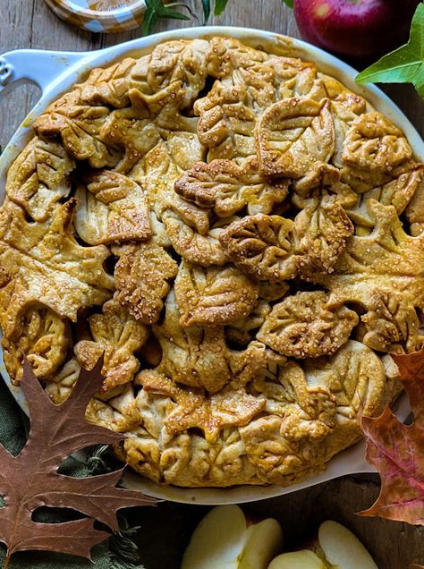 A Salted Bourbon Caramel Apple Pie covered in pastry leaves is cooling on the counter, surrounded by apples and autumn leaves, and a jar of caramel sauce. Bourbon Apple Pie, Best Apple Pie Recipe, The Best Apple Pie, American Apple Pie, Bourbon Caramel, Apple Crisp Easy, Best Apple Pie, Classic Apple Pie, American Desserts