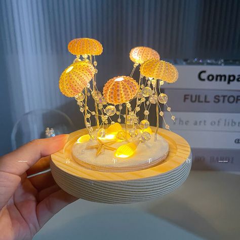 Sea urchin shell jellyfish lamp creative night light atmosphere light handmade DIY gift night lightProduct Details -Name: DIY sea urchin night light -Material: glass+wood -Voltage: ≤36V -Power: 5W -Power supply: USB powered -Note: The production materials and tools are provided. You need to assemble it yourself. We can provide videos to learn how to make it. -Packaging: 1/pack Recommended to buy 3D Flocked Moss Mats Minimalist Plush Carpet Sensory Things To Make, Jellyfish Gift Ideas, Sea Urchin Decor, Sea Urchin Shell Crafts, Jellyfish Lamp Diy, Jellyfish Terrarium, Sea Lamp, Diy Lamp Ideas, Sea Decoration