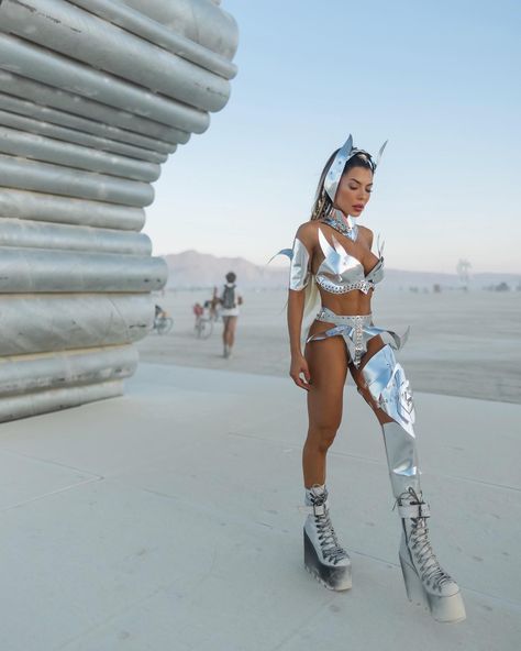 Silver tones slice through the desert haze, a vision of futuristic fashion amidst earthy surrounds. It's a bold celebration of individuality on the sands of creativity 🤩🫦 @thaylise_ferreira 🔥🔥 Mirror Festival Outfit, Burningman Fashion, Desert Festival Outfits, Coachella Style, Burning Man Fashion Woman, Burning Man 2022 Outfits, Burning Man Girls, Burning Man Art Car, Burning Man 2022 Art