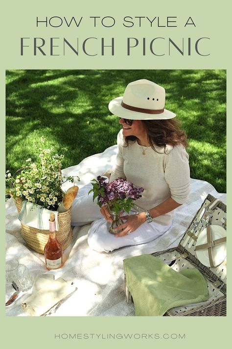 Woman in fedora holding lilacs, on picnic blanket with picnic basket, straw bag with baguette and daisy flowers, bottle of rose wine and glasses outdoors 1920s Picnic, Picnic Dessert Ideas, Bestie Dates, Paris Apartment Decor, Charcuterie Picnic, Picnic Wine, French Picnic, Paris Garden, Wine Picnic