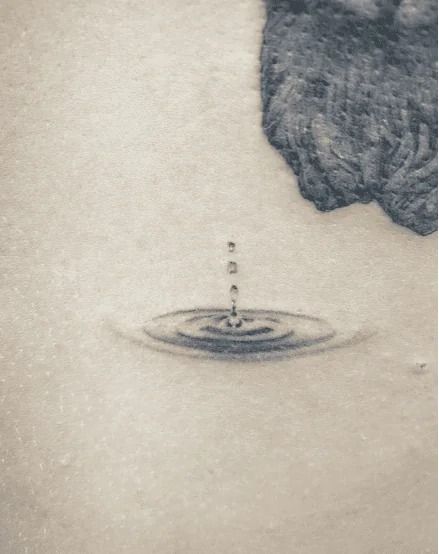 105+ Water Tattoo Ideas To Help You Go With The Flow Ripple Water Tattoo, Drop Of Water Tattoo, Rain Drop Tattoo Ideas, Water Tatoos Ideas, Flowing Water Tattoo, Water Droplet Tattoo, Water Ripple Tattoo, Puddle Tattoo, Water Tatoos