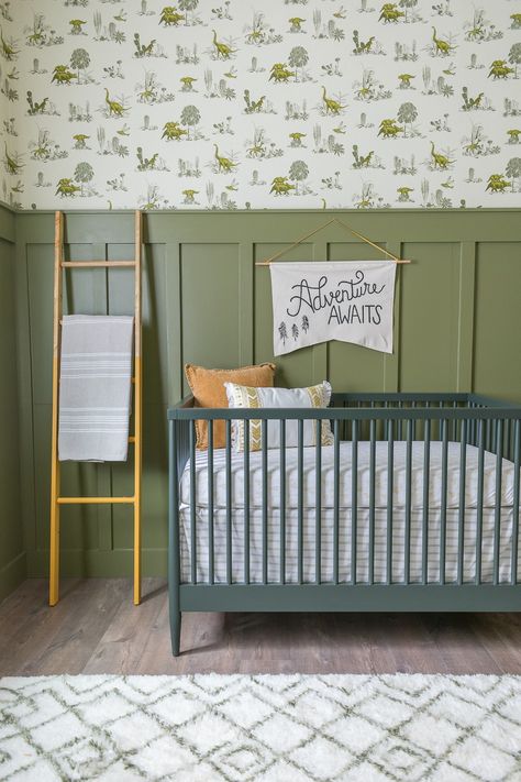 Baby Boy Dinosaur themed nursery will olive green walls, wood paneling, wallpaper, and leather butterfly chair by Beebout Design. Baby Boy Nursery Dinosaur, Dinosaur Nursery Theme, Dino Wallpaper, Boys Room Wallpaper, Dinosaur Nursery Decor, Olive Green Walls, Boy Nursery Themes, Baby Boy Bedroom, Nursery Room Design