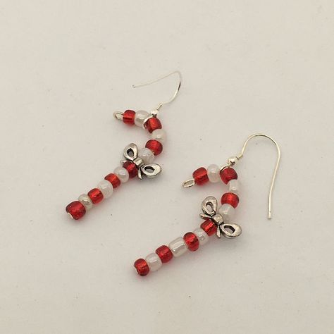 Fun Christmas earrings, beaded candy cane design dangle earrings.  Created with red and white glass seed beads and featuring a a pewter bow.  The canes hang from a sterling silver ear wire.  A great idea for Christmas stocking fillers. The cute earrings drop 4cm in length. They are available to be shipped immediately and will arrive packaged in a kraft paper pillow box ready to give as a gift or as a gift for yourself! Diy Christmas Earrings Beads, Christmas Jewelry Aesthetic, Christmas Seed Bead Jewelry, Beaded Earrings Christmas, Christmas Diy Earrings, Cute Christmas Earrings, Christmas Earrings Beaded, Christmas Bead Earrings, Christmas Earrings Diy