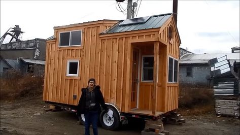 This is an 8×16 tiny house on wheels by Jamaica Cottage Shop. From the outside, you’ll notice a short trailer house with a gabled metal roof with loft dormers, a tiny front porch, and a … 8x16 Tiny House, Tiny House Porch, Small Houses On Wheels, Jamaica Cottage, Caravan Living, Mini Homes, Tiny House Cottage, Pre Fab Tiny House, Tiny House Village