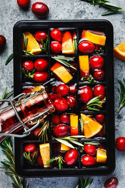 How to Make These Simple & Easy Ice CubesAn ice cube tray filled with all of the ingredients needed to make these pomegranate ice cubes Holiday Drink Ice Cubes, Fruit And Herb Ice Cubes, Fruit Ice Cubes How To Make, Ice Cube Drink Ideas, Xmas Ice Cubes, Pomegranate Ice Cubes, Orange Juice Ice Cubes, Fancy Ice Cubes For Cocktails, Holiday Ice Cubes Cocktails