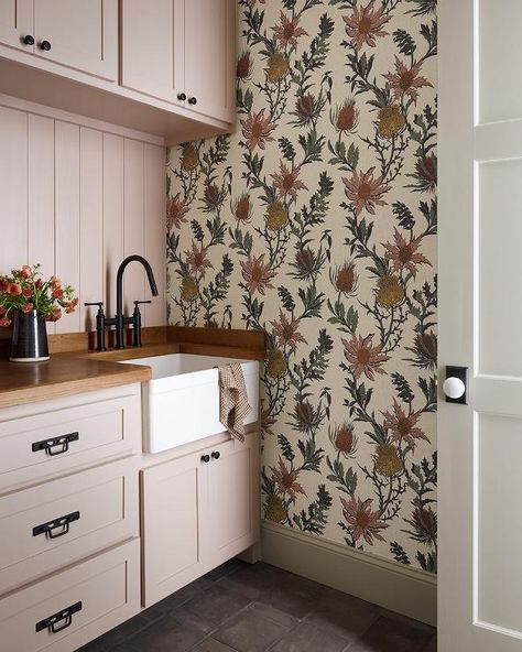 Laundry room features pink cabinets with bronze hardware and a wood countertop with apron sink and an oil rubbed bronze deck mount faucet and pink shiplap trim with bontanical wallpaper. Pink Mudroom, Pink Shiplap, Pink Laundry Room, Shiplap Trim, Cottage Laundry Room, Pink Laundry, Pink Laundry Rooms, Pink Cabinets, Wood Countertop