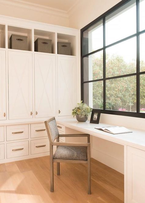 Sun-filled mudroom features a flannel gray chair placed in front of a white built-in desk with storage placed right below windows. Desk Below Window, Mud Room Desk, Transitional Laundry Room, Laundry Room/mud Room, Mudroom Design, Guest Room Office, Home Addition, Room Desk, Storage Places