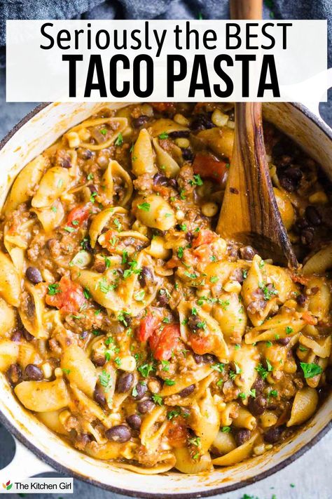 A pot of taco pasta with shell noodles, ground meat, black beans, tomatoes, and chopped herbs. A wooden spoon is stirring the dish. Text at the top reads, Seriously the BEST TACO PASTA. Crockpot Taco Pasta Soup, One Pot Southwest Pasta, One Pot Mexican Pasta, Taco Pasta Crockpot Ground Beef, Taco Pasta Crockpot Recipes, Crockpot Recipes Taco Pasta, Enchilada Pasta Recipe, One Pot Meals Hamburger Meat, Cheesy Taco Orzo