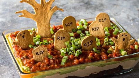 With just a few simple steps, impress your friends and family with this spooky yet delicious taco dip including layers of beans, sour cream, avocado, and salsa. Taco Graveyard Dip, Graveyard Taco Dip, Graveyard Dip, Halloween Tailgate, Menu Halloween, Halloween Potluck, Halloween Party Foods, Halloween Food Appetizers, Hocus Pocus Party