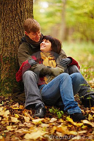 Romantic Couple Sitting Under A Tree Together Couple Sitting Under Tree, Couple Sitting Reference, People Sitting Under Tree, Sitting Between Legs Couple Pose, Couple Under Tree, Sitting Hug Couple, Sitting Under A Tree Drawing Reference, Sitting Together, Two People Sitting Together