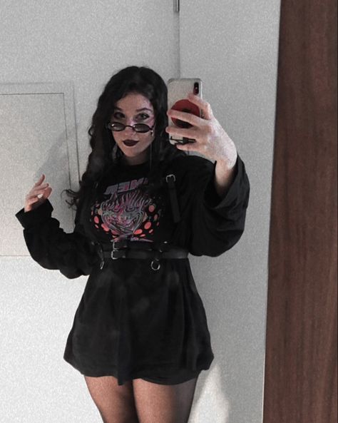 Girl standing in front of mirror taking a selfie. Dressed in an oversized Sweater with a demon print in the front and a chest harness around. Long curly hair, dark makeup and wearing sunglasses. Oversized T Shirt With Harness, Sweater Goth Outfit, T Shirt Harness Outfit, Tshirt With Harness, Harness Over Sweater, Sweater With Harness, Alt Tshirt Outfits, Goth Oversized Shirt Outfit, Harness Outfit Aesthetic