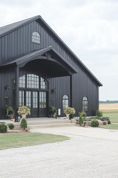 Modern black metal building with arched windows. Unravel the quirky charm and rock-solid perks of metal building homes, where modern design meets durable dinosaur-era construction vibes! Black Metal Commercial Building, Metal Shop Colors Exterior, Metal Buildings Shop, Pole Barn Exterior Ideas, Black Shop House, Modern Warehouse Design Exterior, Industrial Shed Design, Black Pole Barns, Black Metal Barn