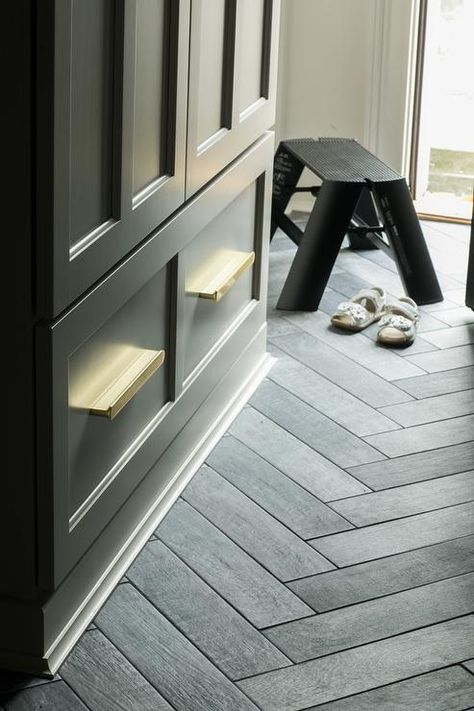 Slate herringbone floor tiles add chic style to a mudroom boasting black cabinets accented with brass cup pulls. Slate Herringbone Tile Floor, Herringbone Shower Floor, Herringbone Floor Tiles, Black Herringbone Tile, Herringbone Tile Floors, Entryway Tile, Mudroom Flooring, Painting Tile Floors, Herringbone Wood Floor