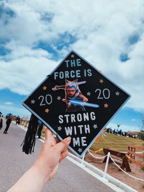 A blue sky with clouds and a hand holding a graduation cap decorated with Ahsoka Tano in the middle. Words around Ahsoka read “The force is strong with me.” Ahsoka Graduation Cap, Actor Graduation Cap, Grad Cap Ideas Star Wars, Starwars Graduation Caps, Graduation Cap Star Wars, Star Wars Graduation Cap Ideas, Graduation Cap Designs Star Wars, Httyd Graduation Cap, Star Wars Graduation Cap