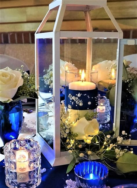 Modern Vintage Lantern Centerpiece with fresh flowers and royal blue embellishments Royal Blue Centerpieces, Royal Blue Wedding Decorations, Quince Centerpieces, Cobalt Blue Weddings, Royal Blue Wedding Theme, Classic Blue Wedding, Quinceanera Centerpieces, Blue Wedding Centerpieces, Blue Wedding Decorations