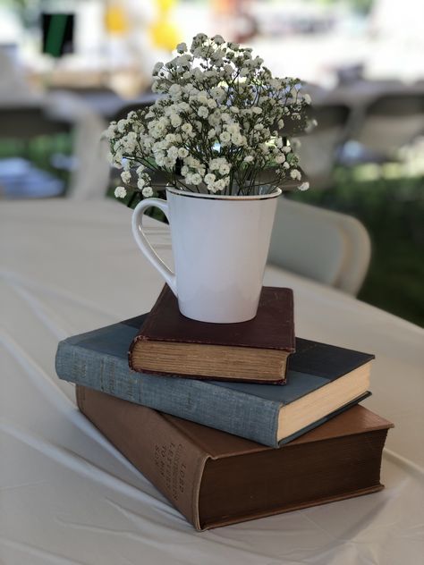 Book Inspired Centerpieces, Bookworm Graduation Party, Baby Shower Book Centerpieces, Book Club Table Decor, Vintage Book Themed Party, Graduation Party Book Theme, On To The Next Chapter Graduation Party, Mug Centerpiece Ideas, Travel Graduation Party Ideas