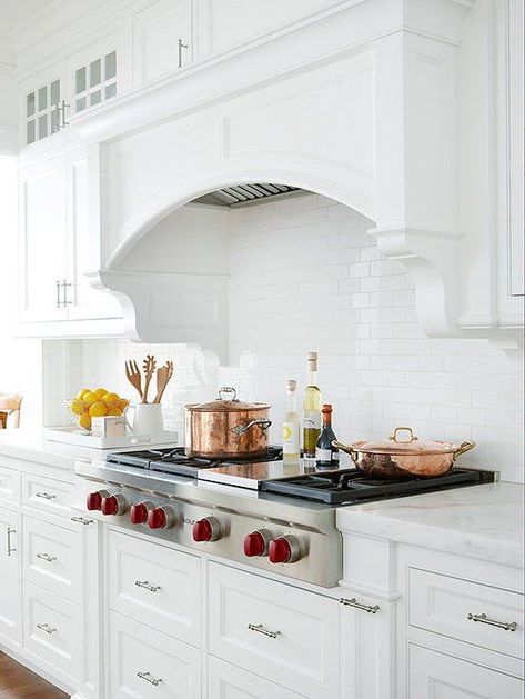 A substantial arch on this range hood presents a classic look. Custom moldings bring even more visual interest, while allowing the hood to meld with the cabinetry. White Cottage Kitchens, Kitchen Hood Ideas, Spanish Style Kitchen, Kitchen Hood Design, Kitchen Vent Hood, Kitchen Vent, Kitchen Range Hood, Cottage Kitchens, Kitchen Hoods