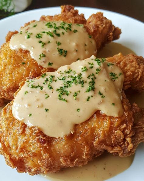 Pan Fried Chicken with Cream Gravy 🍗🍛 Ingredients: - 4 boneless, skinless chicken breasts - 1 cup all-purpose flour - 1 teaspoon paprika - 1/2 teaspoon garlic powder - Salt and pepper, to taste - 1/4 cup vegetable oil - 2 tablespoons unsalted butter - 1 cup whole milk - 1/2 cup chicken broth Instructions: 1. In a shallow bowl, mix flour, paprika, garlic powder, salt, and pepper. Dredge the chicken breasts in the flour mixture, coating well. 2. Heat vegetable oil in a large skillet over me... Garlic Fried Chicken, Chicken Fried Chicken, Brooklyn Food, Cream Gravy, Gravy Ingredients, Pan Fried Chicken, Fried Chicken Breast, Shallow Bowl, Yummy Comfort Food