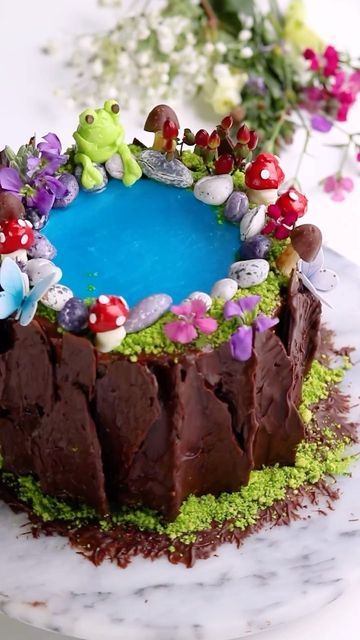 Sheri Wilson on Instagram: "Fairy Pond 🍄 Another variation on the Enchanted Forest Cake tutorial from my book Caketopia (available now on amazon) I’ve had the idea of a fairy pond cake floating around in my head for awhile, and thought using jello would be perfect addition! I added edible glitter to it before pouring onto the cake, and it was magical! 🤩 Some tips for adding jello to your cake -Frost the area with buttercream and chill until firm to the touch before pouring in the jello. -Mak Enchanted Forest Cake, Waterfall Cake, Fairy Pond, Pond Cake, Buttercream Cake Designs, Jello Cake, Up Cake, Woodland Cake, The Enchanted Forest