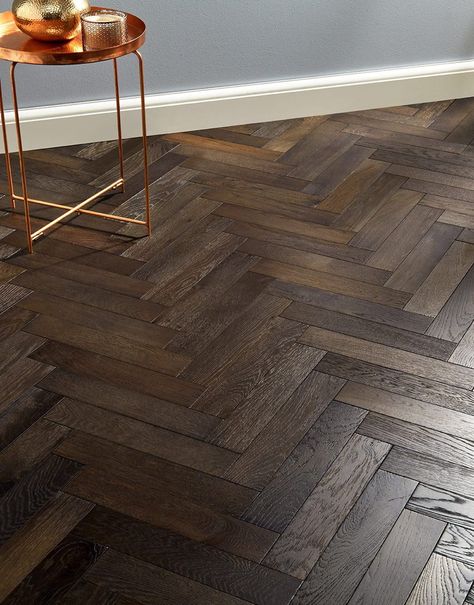 Are you looking for a change? Subtle smoky undertones mixed with dark chocolate shades, mesmerizing grains and knots as well as eye-catching tones make this engineered floor a perfect choice for any interior. Our Oxford Herringbone Vintage Oak adds character and natural charm to classic or modern living spaces. Designed to stand the test of time, the floor measures 14mm in thickness and comes with a tough 3mm top layer. The surface boasts a brushed finish that enhances the features of solid oak. Don't forget to checkout our accessories page, there you can the finishing pieces for your flooring! Dark Herringbone Floor, Engineered Wood Floors Oak, Dark Wooden Floor, Direct Wood Flooring, Wood Floor Design, Traditional Eclectic, Herringbone Wood Floor, Herringbone Wood, Dark Wood Floors