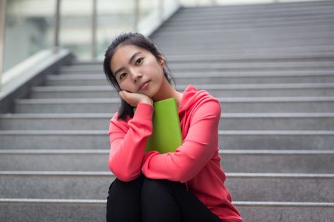 A young person sits on a staircase, one arm wrapped around a green book, the other supporting their head which rests in their hand. Person Resting Head On Hand, Resting Head On Hand, Head On Hand, Green Book, Black Dating, Indian People, Meet Guys, Flirting Quotes For Her, Person Sitting