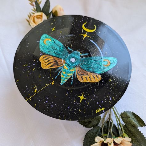 Hand-painted vinyl record featuring a mystical design of a moth, moon, and stars 🌙🦋✨ This unique piece blends nature and the cosmos, adding a mysterious and magical vibe to any space. Perfect for art lovers looking for something different and inspired. 🎨💫 #Handpainted #MysticalArt #VinylArt Painted Record Albums, Grunge Record Painting Ideas, Trippy Record Painting, Acrylic Painting On Vinyl Records, Painted Records Vinyl Trippy, Painted Vinyl, Vinyl Record Art, Record Art, Mystical Art