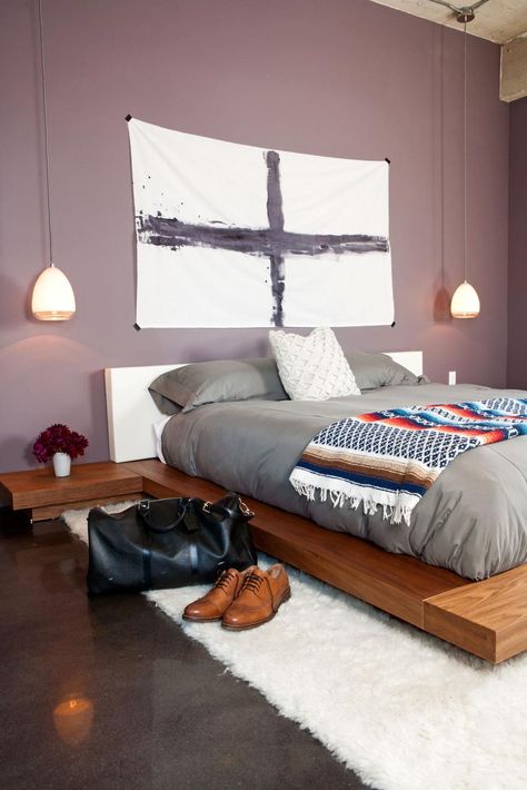 This modern master bedroom features light purple walls, a platform bed and bedside pendant lights. Minimalist artwork, gray bedding and dark wood tones create a subtle masculine vibe in the space. Bedroom Masculine, Bachelor Bedroom, Small Bedroom Remodel, Masculine Bedroom, Modern Minimalist Bedroom, Purple Bedroom, Minimalist Bedroom Design, Bedroom Color Schemes, Bedroom Paint Colors