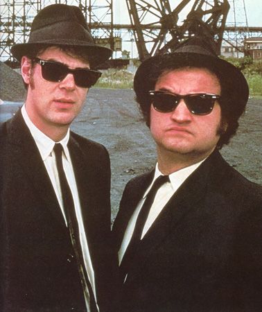 The Blues Brothers From The Blues Brothers      What to wear: White collared shirt, black suit, black sunglasses, and a fedora. Add sideburns.     How to act: Jam out on a harmonica all night. Blues Brothers Costume, Snl Characters, Movie Duos, Blues Brothers 1980, Septième Art, Blues Brothers, Ray Ban Aviator, Men In Black, Funny Halloween Costumes