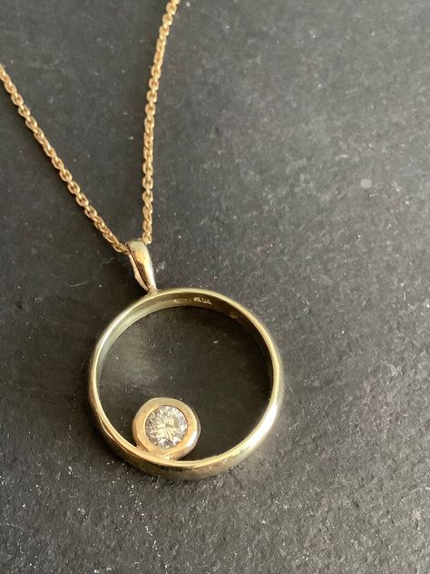 "This was an 18ct gold diamond ring  But we converted it to a pendant  The  diamond is 0.25ct ,quarter carat . A very clean ,white ,bright top quality diamond,with no visible inclusions. Diamond 6mm diameter in its setting  the circle is 14ct gold , stamped 585.  Pendant 17mm diameter. Hanging on a  18\" silver gilt chain  I have done a few of these and can convert your own ring if you are in uk  It's a lovely way to wear inherited engagement rings." Round Pendant Jewelry With Diamond Accents, Pendant Made From Wedding Ring, Reset Diamond Ring Into Necklace, Silver Diamond Necklace With Round Pendant In 14k Gold, Keepsake Diamond Pendant Jewelry, Diamond Circle Necklace, Round Diamond Pendant, Diamond Pendants Designs, Diamond Pendants