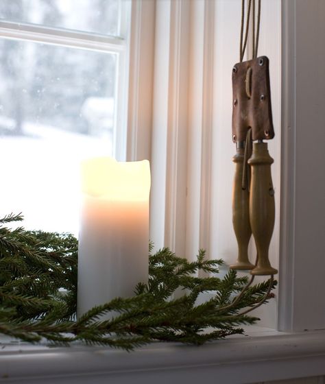 Add warmth to a drab window sill by placing a white candle at the center of a pine branch. Windowsill Christmas Decorations, Christmas Kitchen Window Sill, Christmas Decor Window Sill, Christmas Window Sill Decorations, Christmas Window Ledge Decor, Large Window Sill Decor, Window Ledge Christmas Decor, Christmas Window Sill Ideas, Christmas Window Sill Decor