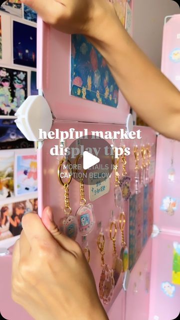 Jazlynn on Instagram: "Here are some tips I learned from my markets this summer 🥰 

✨ Command Hooks for Keychains and Charms ✨
I love command hooks because they hold on my keychains so well! I don’t bother removing them bcuz they don’t fall, so I keep them on my display when I pack up. This way I don’t have to replace my items every new market I attend and I can just pull out the finished pink display board! Saves me a lot of time to not have to put up ALL my keychains again. Although my charms have a much slimmer string and those do fall off so I have to constantly remove and add those 🙈. 

Pretty sure I got this idea from @heluhime! 

✨Add some cute decorations!✨ 
It helps to give your display a bit of your personality and art vibes to attract people! This is mostly personal preference Display Keychains, Keychain Display Ideas, Convention Booth, Pink Board, Cute Decorations, Attract People, Keychain Display, Out Of Space, Command Hooks