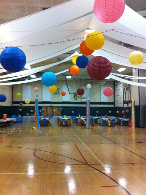 Trying to transform a gigantic gym into a fun, colorful dance hall didn't cost much!  $200 on paper lanterns, a couple of rolls of plastic table cloths, some white christmas lights, chair ties and some imagination is all it took. Family School Dance, Dance Marathon Decorations, School Gym Dance Decorations, School Dance Decorations Cheap, Elementary School Dance Decorations, Gym Dance Decorations School, School Dance Decorations, School Dance Themes, School Disco