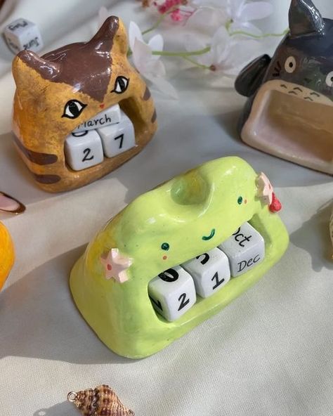 B&P • Clay + Jewel Artist on Instagram: "Upcoming New year demands new calenders 🤍
.
Go pick yours from the website || 
•Froggo 
•Cat Bus
•Calcifer 
•Totoro
.
(Stationery , art , studio ghibli , cozy , indian small biz , memopads , posters , stickers , handmade shop )

#studioghibli #totoro #posters #cozy #aesthetic #cutestationery #stationeryindia #ghibli #ghiblilove #clay #claycharms #fyp #handmade #handpainted #howlsmovingcastle #kikideliveryservice #magnet #foryou #foryoupage #reels #deskbuddy #calendar #ghiblicalendar #perputalcalendar" Clay Calendar, Studio Ghibli Clay Art, Ghibli Merch, Cat Bus, Art Studio Ghibli, Stickers Handmade, Cat Calendar, Desk Buddy, Clay Magnets