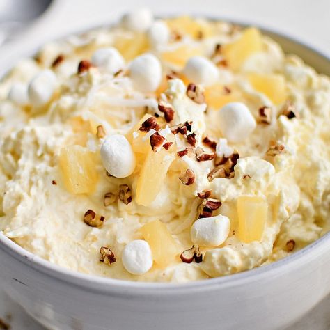 Pineapple Fluff is a light and creamy no-bake dessert recipe that comes together in minutes. It's made with a delicious blend of crushed pineapple, cream cheese, instant vanilla pudding, whipped topping, marshmallows, and shredded coconut - perfect for potlucks and family gatherings. Pineapple Mousse, Pineapple Fluff, Snickers Salad, Grape Salad Recipe, Fluff Salad Recipes, Easy Fruit Salad Recipes, Fluff Recipe, Coconut Pudding, Fruit Salad Easy