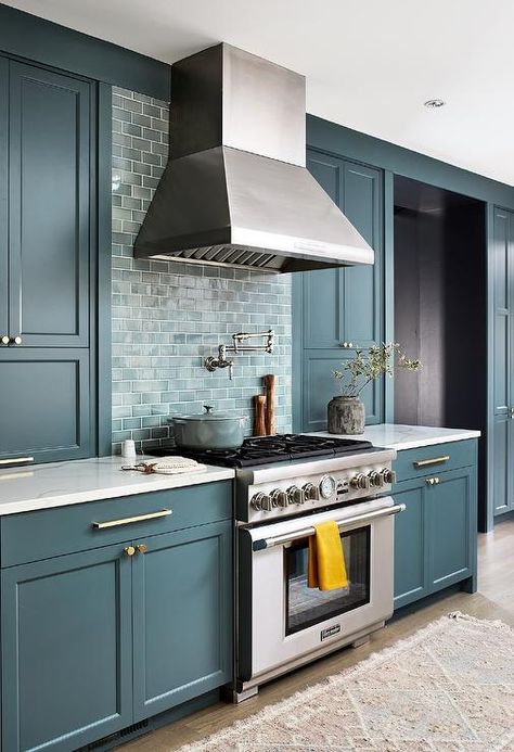 Teal cabinets with brass hardware, teal kitchen mini subway backsplash tiles over a thermador stove and a pink vintage runner are featured in this contemporary kitchen. Teal Kitchen Cabinets, Blue Green Kitchen, Teal Cabinets, Teal Kitchen, Blue Kitchen Cabinets, All White Kitchen, Blue Cabinets, Kitchen Cabinet Colors, Blue Kitchens