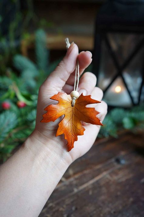 Our boldly colored leather maple leaf ornaments are hand carved and dyed to ensure they are as unique as the leaves that inspire them. Hand dyed with an ombre technique they will bring a natural warmth to your home decor. Strung from all natural hemp or jute twine and finished with a recycled wooden bead they make the perfect addition to your tree this year or as an extra special adornment on the gifts underneath Hand Carved and Dyed Natural Hemp or Jute Twine Wooden Bead DIMENSIONS - Leaves mea Druid Craft, Leather Gift Ideas, Autumn Accessories, Diy Leather Projects, Leaf Ornament, Leather Leaf, Leather Scraps, Leather Workshop, Leather Carving