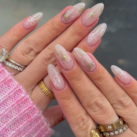 These dreamy soft pink nails are decorated with delicate golden stars and white patterns, creating an ethereal, fairy-tale look. The soft ombré base, paired with fine, intricate details, makes this design perfect for those who appreciate a whimsical yet elegant style. Ethereal Nails, Nails 2025, Ethereal Fairy, Soft Pink Nails, 2025 Trends, New Year's Nails, Golden Star, White Patterns, Intricate Details