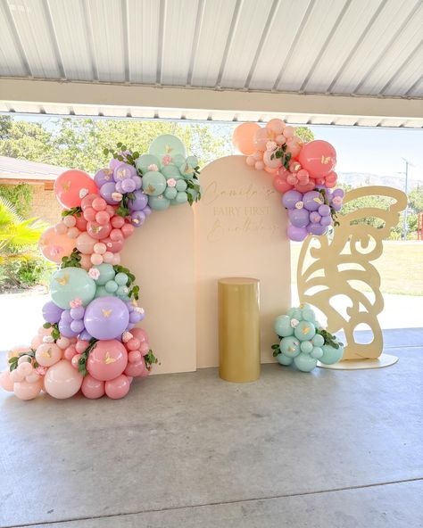 Camila’s Fairy First Birthday 💕 To say this event was magical is an understatement. 💫 If you are planning a first birthday party we can help you create the dreamiest backdrop for your event. To inquire please fill out our inquiry form on our website or send us an email to luxanballoons@gmail.com In this event we provide the: - chiara walls - gold cylinder cake stand - vinyl signage - balloon garland and the add-ons Butterfly wing: unknown vendor Fairy First Birthday Backdrop Ideas, Floral And Butterfly Birthday Theme, Fairy Theme Backdrop, Fairy Birthday Balloon Garland, Fairy Balloon Arch, Fairy First Birthday Party Backdrop, Fairy First Birthday Balloon Arch, Fairy Birthday Backdrop, Fairy First Balloon Arch