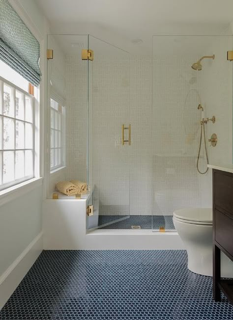 Navy penny floor tiles lead to a walk-in frameless glass shower accented with a brass handle. Gömda Rum, Penny Tiles Bathroom, Blue Bathroom Tile, Penny Tile, Shower Floor Tile, Floor Bathroom, Cottage Bathroom, Transitional Bathroom, Boys Bathroom