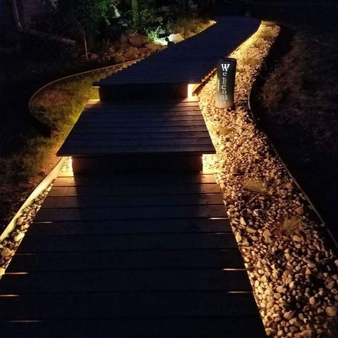 Wooden boardwalk lit with rope lights. Boardwalk Deck, Boardwalk For Yard, Boardwalk Garden Path, Boardwalk Pathway, Lake Stairs, Wooden Boardwalk Pathways, Wooden Bollard Lights, Outdoor Deck Decorating, Wooden Path