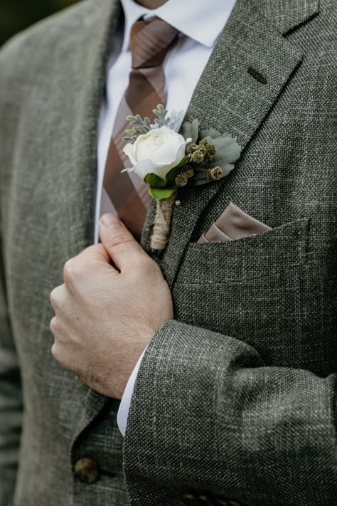 Brown plaid tie and silk pocket square with forest green tweed suit jacket. Artificial silk boutonniere with greenery. Ideas for groom attire and wedding suit inspiration for an autumn lake wedding in Waskesiu Lake, Prince Albert National Park, Saskatchewan, Canada. Intimate lakeside wedding with vintage rustic decor and details at Waskesiu Community Hall by Saskatoon wedding photographer Copperblue Photography and Design. #saskatoon #yxe #yxewedding #saskatchewan #waskesiu Green Tweed Wedding Suit Groom, Green Suit Brown Tie, Cottagecore Wedding Groom, Cottagecore Groom Outfit, Green Tweed Suit Wedding, Autumn Wedding Suit, Forest Wedding Suit, Forest Green Wedding Suit, Green Wedding Suit Groom