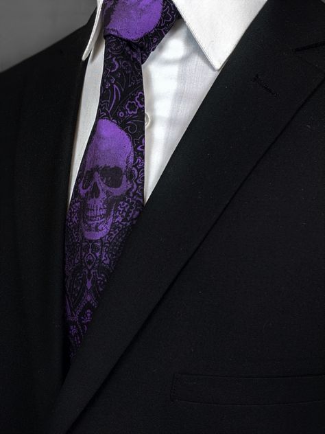 This gothic wedding skull tie is hand dyed by Eds Neckties. Features a background with shades of black and skulls with shades of purple. Available as an extra-long tie. Pocket Square not included. #Purple #Skull #Gothic #Necktie #PurpleNecktie #SkullNecktie #GothicNecktie Black And Purple Suits For Men, Black And Purple Wedding Ideas, Dark Purple Wedding Dress, Black And Purple Suit, Purple And Black Wedding Theme, Black And Purple Wedding Theme, Black And Purple Wedding Dress, Dark Purple Wedding Theme, Black And Purple Wedding