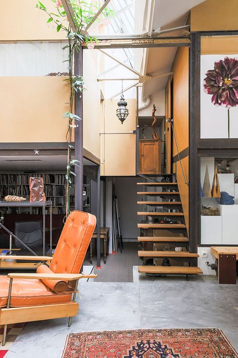 This two-bedroom industrial loft lies inside a converted foundry in Paris’s Roquette district and features a soaring atrium living space. The 2,400 sq ft French home sits beneath the original factory roof, which dates from the early 20th century, and has a saw-toothed, complex metal frame design. Photo: c/o Patrice Besse #property #paris #architecture #design Paris Penthouse, White Warehouse, Warehouse Living, Wooden Partitions, Warehouse Home, Exhibition Room, Floating Staircase, Industrial Bedroom, Industrial Living