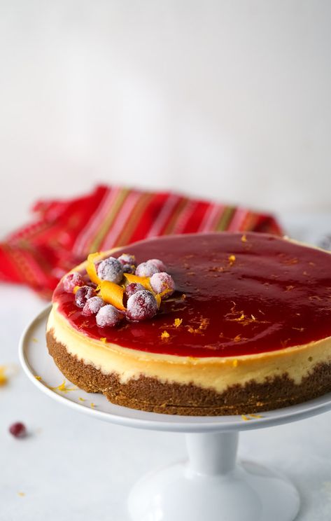 This cranberry orange cheesecake recipe is a MUST this holiday season. With a gingersnap crust, a decadent and creamy orange cheesecake is topped with a sweet-tart cranberry sauce. #cheesecake #cranberrycheesecake #orangecheesecake Sauce For Cheesecake, Peppermint White Chocolate Cheesecake, Cranberry Orange Cheesecake, Orange Cheesecake Recipes, Christmas Cheesecake Recipes, Orange Cheesecake, Cranberry Orange Sauce, Holiday Baking List, Cranberry Cheesecake