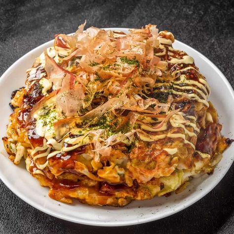 Essentially a Japanese pancake, okonomiyaki was invented before World War II. The origin of the pancake in Japan can be traced back to the Edo period (between 1683 and 1868). During that time, a dessert called funoyaki was served at Buddhist ceremonies. It evolved during the Meiji period and the sukesoyaki was born. In the 20s and 30s, more sauces began to be used and the dish came to be known as yoshokuyaki. The term ‘okonomiyaki’ was only used in Osaka in the 30s. Simultaneously, a similar pan Okonomiyaki Aesthetic, Japanese Pancake Okonomiyaki, Oyaki Japanese, Hiroshima Okonomiyaki, Traditional Japanese Food, Okonomiyaki Recipe, Okonomiyaki Sauce, Food In Japan, Herb Butter Recipe